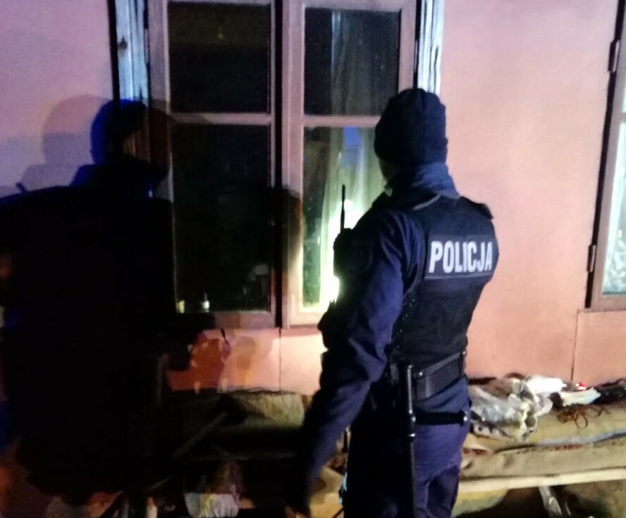 Polscy policjanci badają miejsce zbrodni w nocy.