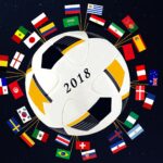 Piłka nożna Mistrzostw Świata 2018 otoczona flagami krajów uczestniczących.