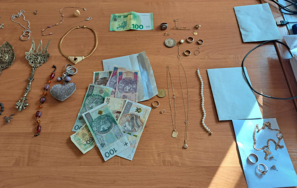 Odzyskano skradzioną złotą biżuterię, gotówkę (złotówki i euro) oraz inne wartościowe przedmioty ułożone na stole.