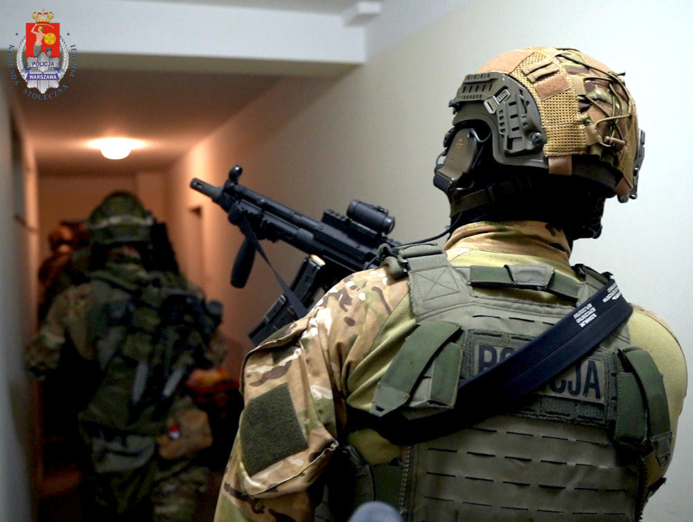 Polscy oficerowie SWAT w ubraniach taktycznych przeprowadzają nalot.