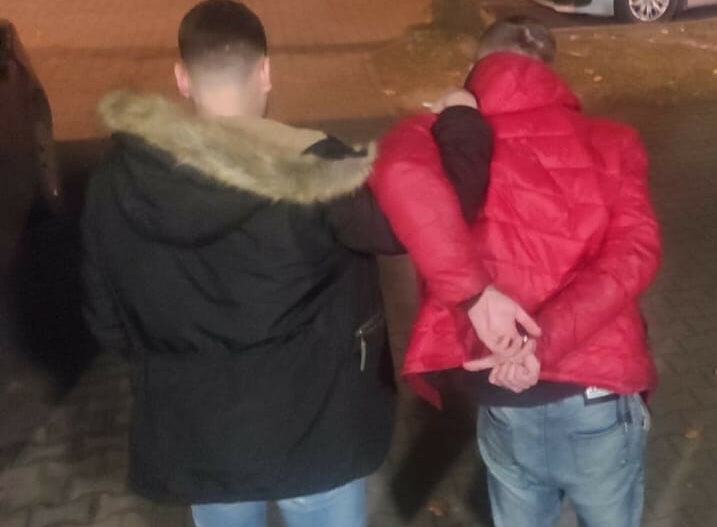 Policjant aresztujący podejrzanego z kajdankami.