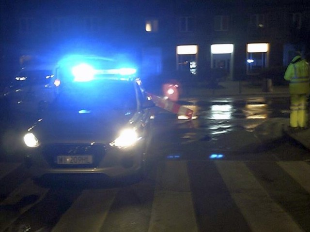 Pojazd uprzywilejowany w nocy z migającymi niebieskimi światłami na miejscu wypadku.