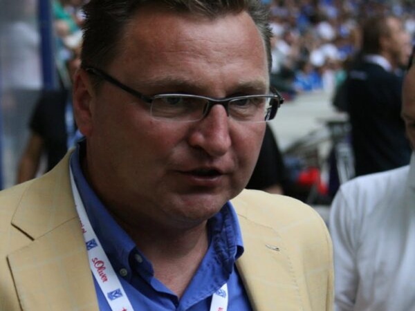 Portret z bliska syna Johana Cruyffa, Jordiego Cruyffa, w okularach i beżowej marynarce.