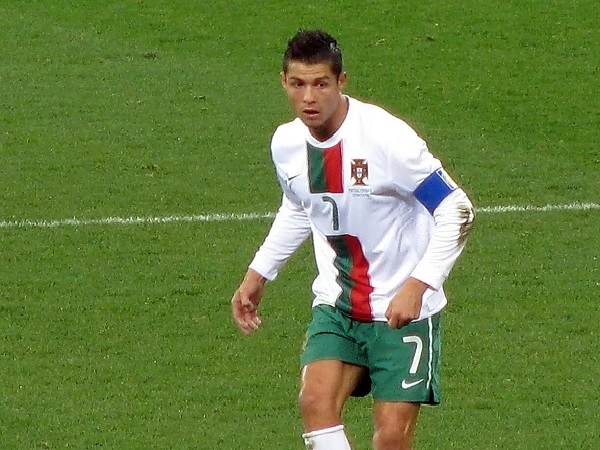 Cristiano Ronaldo, ubrany w koszulkę Portugalii z numerem 7, na boisku piłkarskim.