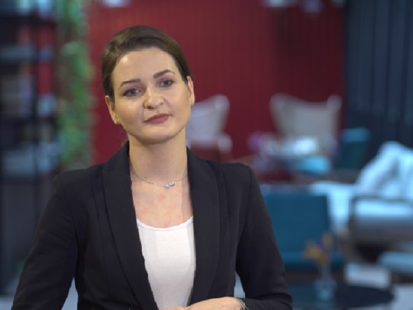 Profesjonalna kobieta w czarnym blezerze, patrząca zamyślona.