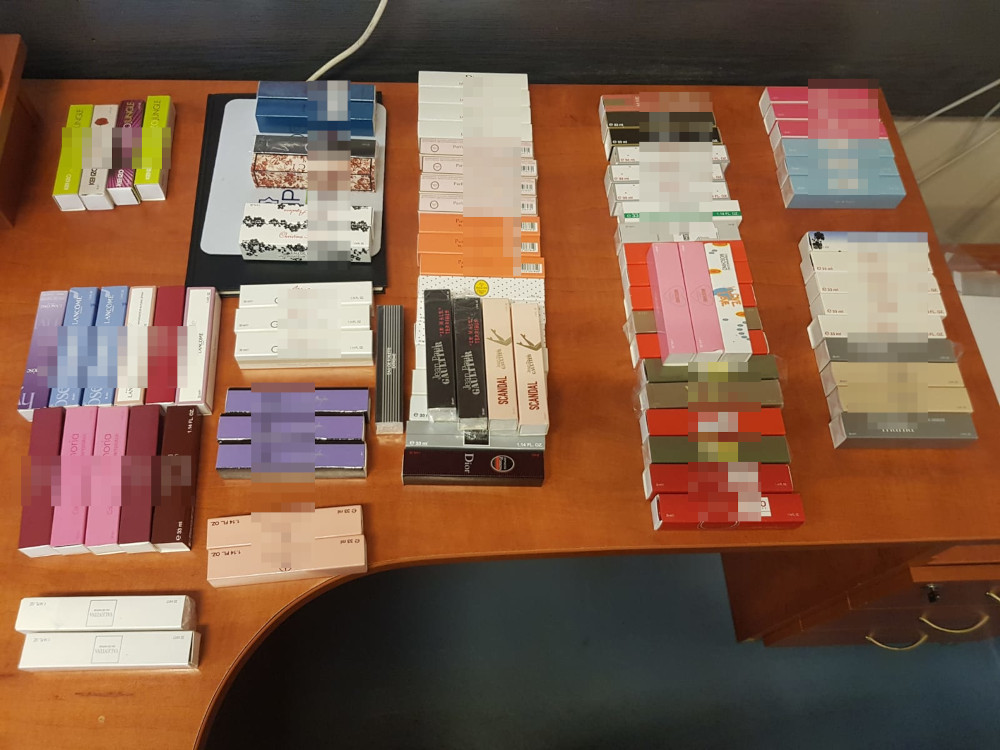 Ekspozytor na blacie z różnymi pudełkami perfum, różnych marek i rozmiarów