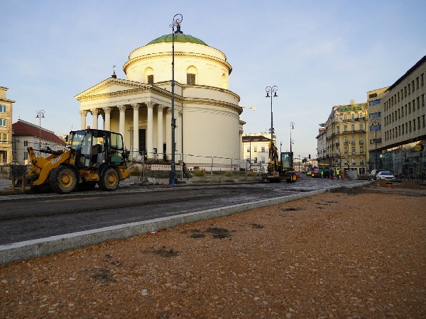 Budowa drogi w pobliżu klasycznego budynku w Warszawie, Polska. Obecny jest ciężki sprzęt.
