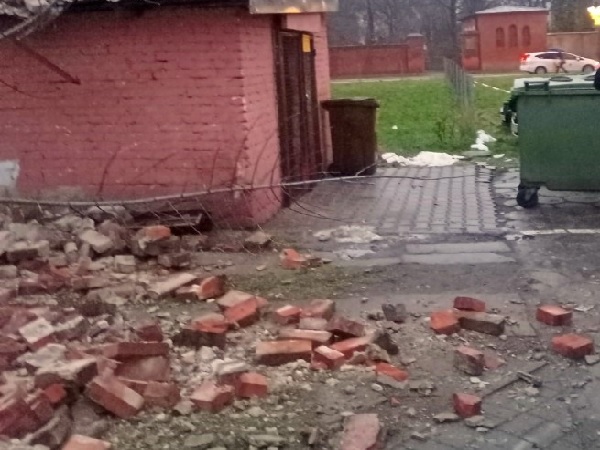 Gruzy zawalonej ceglanej ściany w pobliżu budynku.