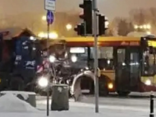 Autobus zatrzymał się na zaśnieżonym skrzyżowaniu, w pobliżu znajdował się pług śnieżny i motocykl.