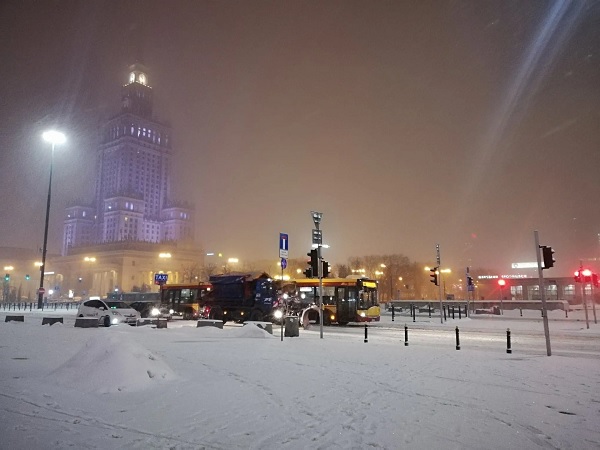 Zaśnieżona Warszawa nocą, w tle widoczny Pałac Kultury i Nauki