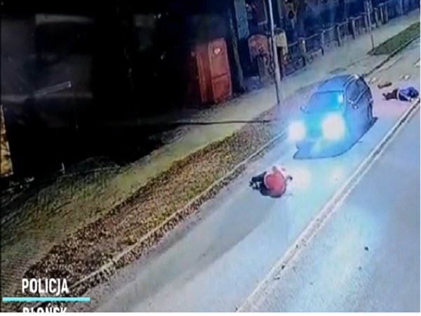 Nagrania z monitoringu nocnego pokazują samochód zatrzymany na drodze w pobliżu rannych. Widoczna jest POLICJA.