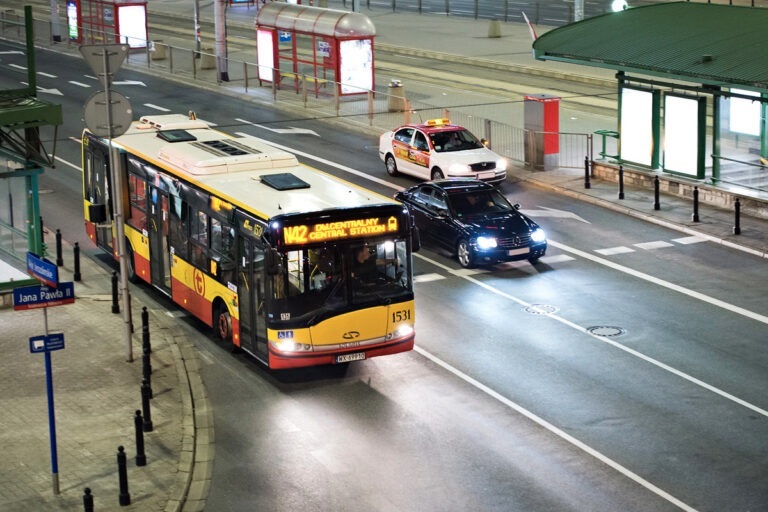 Nocna scena uliczna miasta: autobus (linia 142 do Dworca Centralnego) i samochody.