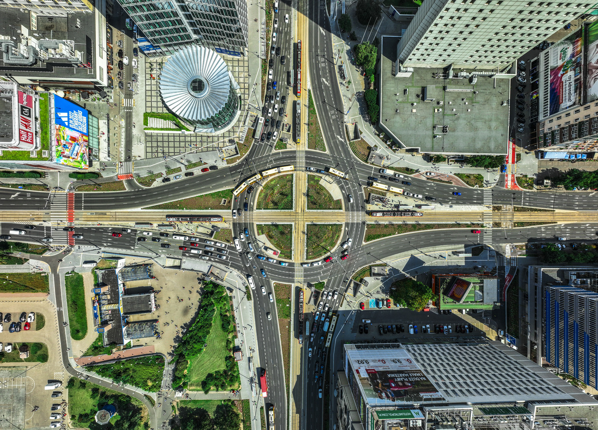 Widok z lotu ptaka na skrzyżowanie miasta z tramwajami i dużym natężeniem ruchu.
