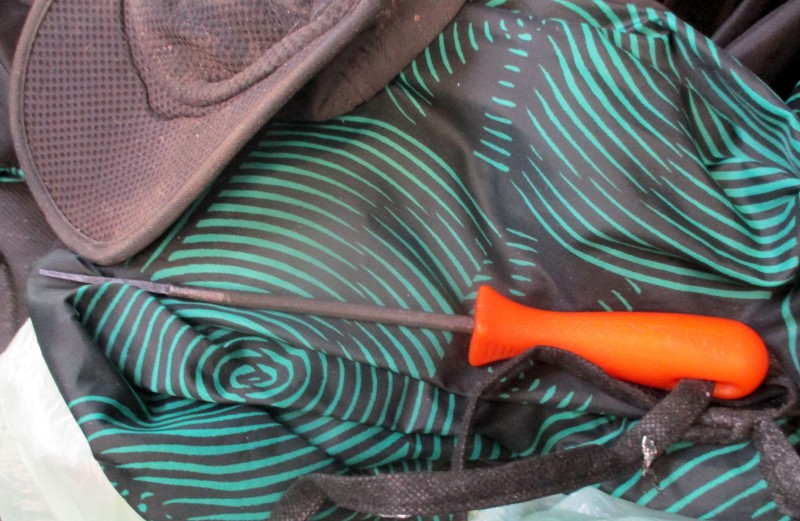 Teczka z pomarańczowym uchwytem spoczywa na tkaninie w kolorze turkusowym.