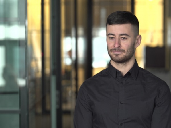 Mężczyzna w czarnej koszuli, zamyślony wyraz twarzy