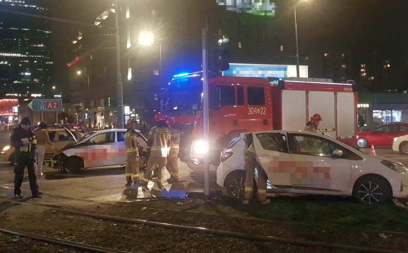 Nocna scena wypadku samochodowego ze strażakami i uszkodzonymi pojazdami. Na miejscu pojawił się wóz strażacki 304-22.