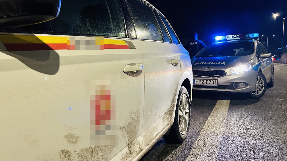 Samochód policyjny zatrzymuje pojazd w nocy. Widoczna tablica rejestracyjna HPZ-B731.
