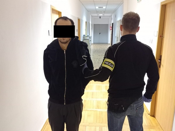 Policjant aresztujący podejrzanego na korytarzu. POLICJA