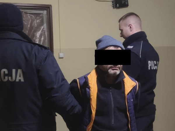 Policjanci eskortują podejrzanego w areszcie.