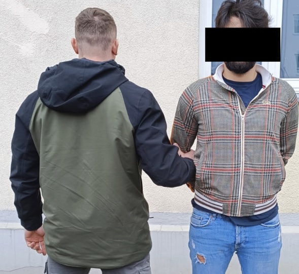 Policjant aresztujący podejrzanego w kajdankach