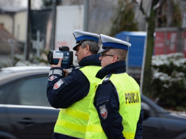 Dwóch polskich policjantów używa pistoletu pomiarowego