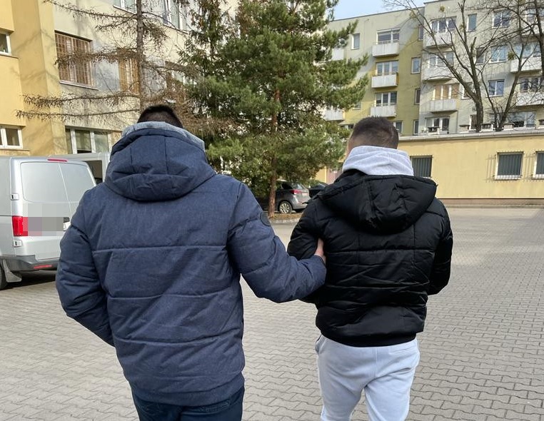 Dwóch mężczyzn w zimowych kurtkach, jeden w granatowym, a drugi w czarnym, idą razem. Aresztować?