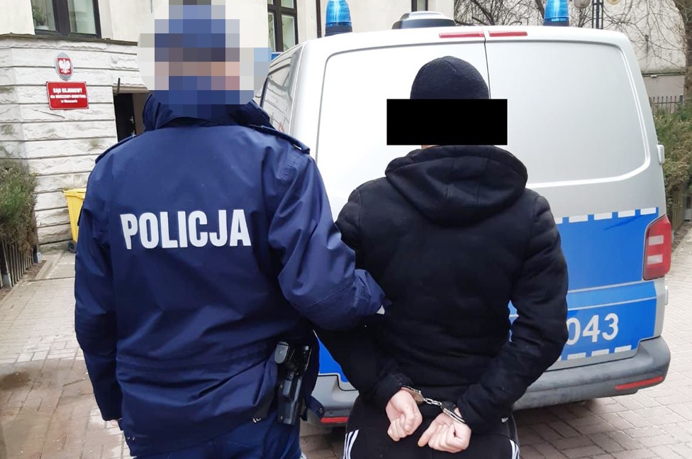 Policjant aresztujący podejrzanego w kajdankach. POLICJA