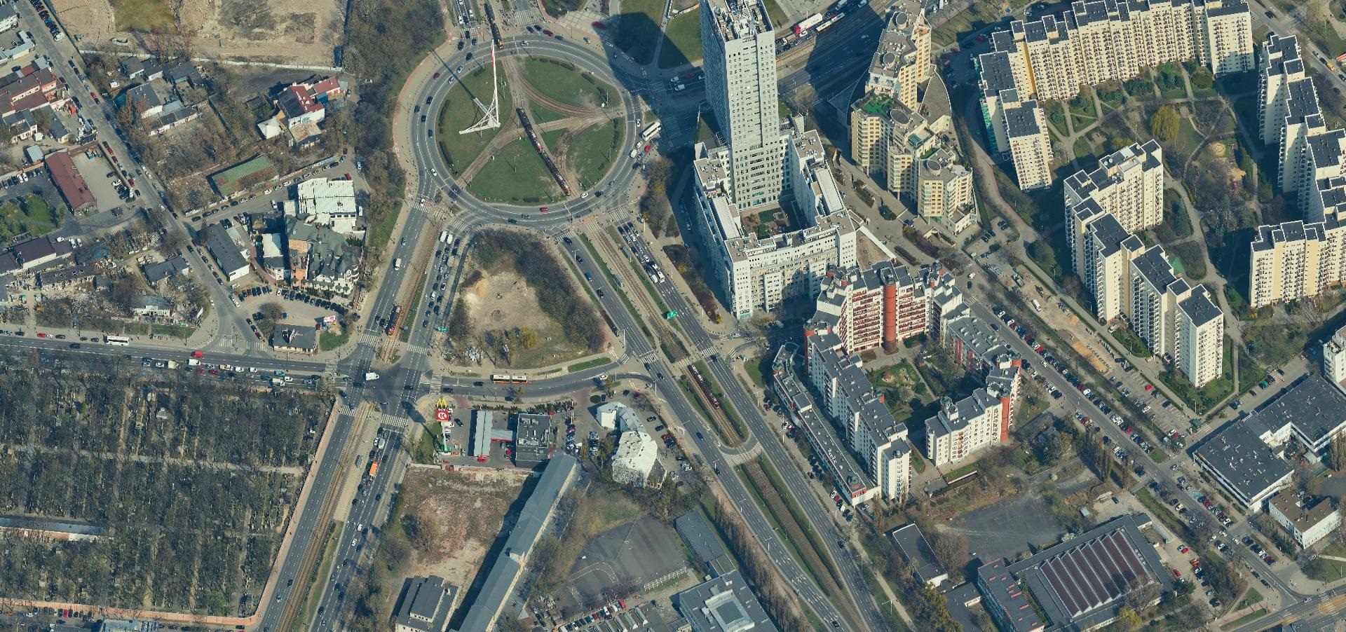 Widok z lotu ptaka na skrzyżowanie miasta z wieżowcami i rondem.