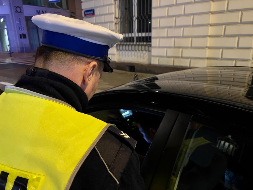 Policjant przeprowadzający kontrolę drogową w nocy