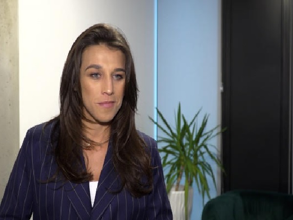 Zdjęcie kobiety w granatowej marynarce w prążki.