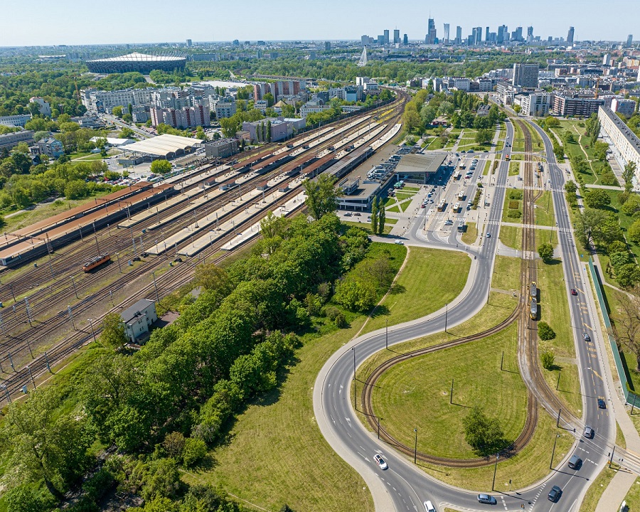 Widok lotniczy dworca kolejowego w Warszawie i otaczającej go panoramy miasta, ukazujący planowanie urbanistyczne i infrastrukturę transportową.