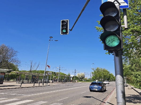 Zielone światło na skrzyżowaniu w mieście z przystankiem taksówek i autobusów.