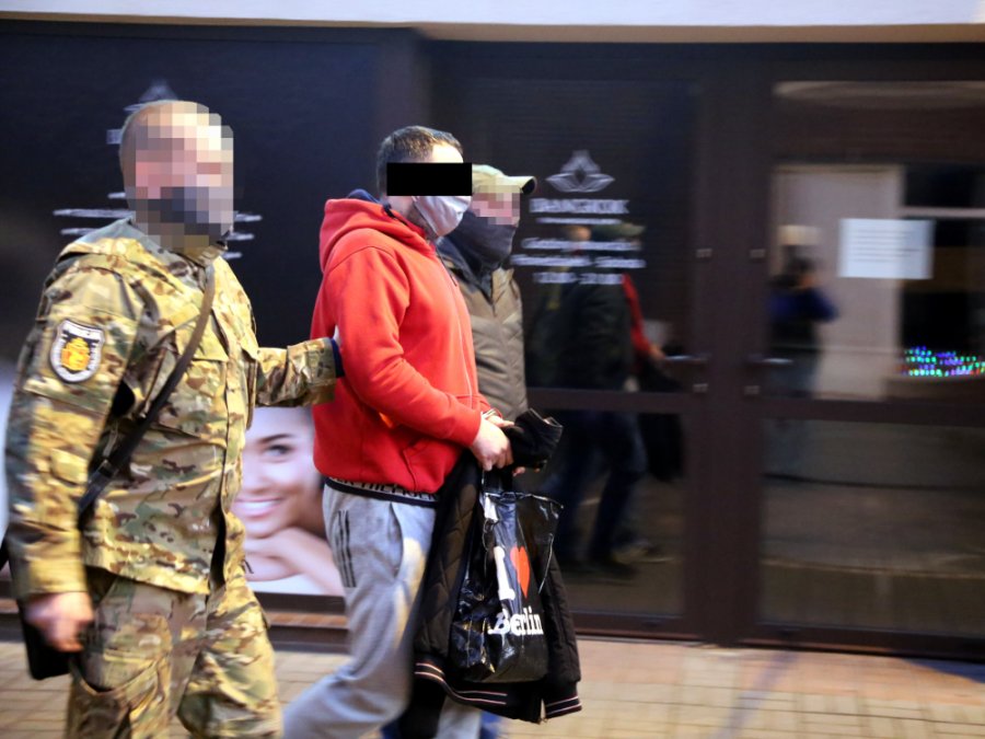 Policjanci zatrzymują podejrzanego nocą na ulicy miasta.