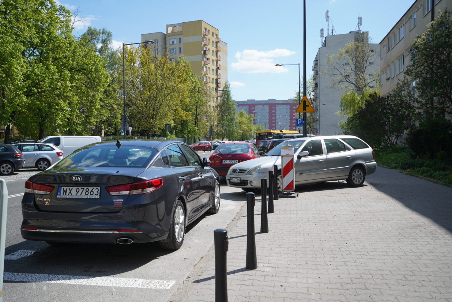 Samochody zaparkowane na ulicy miejskiej, widoczne numery rejestracyjne WX 97863.