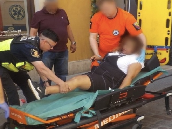 Ratownicy medyczni pomagają rannej kobiecie na noszach