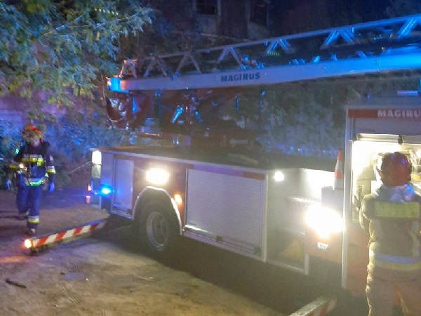 Strażacy w nocy z wozem strażackim Magirus