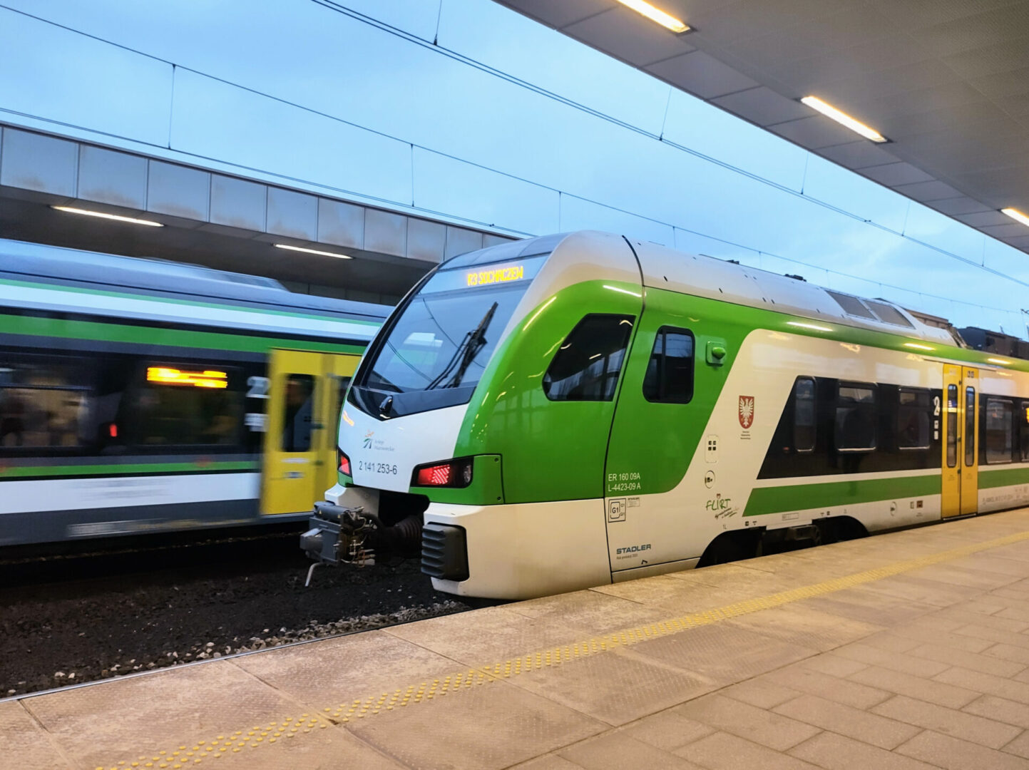Zielono-biały pociąg Stadler FLIRT na peronie stacji
