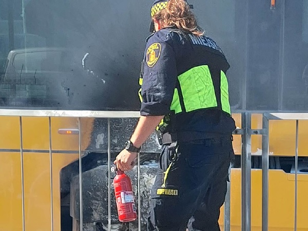 Policjant używa gaśnicy w płonącym autobusie