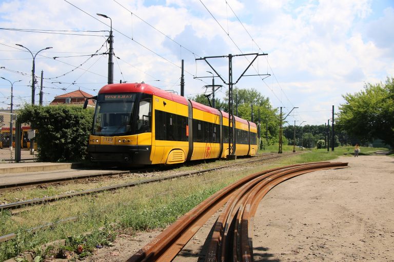 Nowoczesny żółty tramwaj na torach, transport miejski