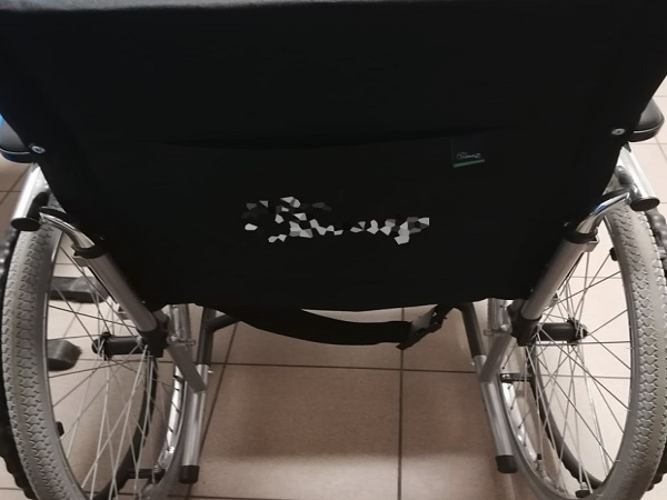 Lekki wózek inwalidzki z czarnym siedziskiem z tkaniny i srebrną ramą