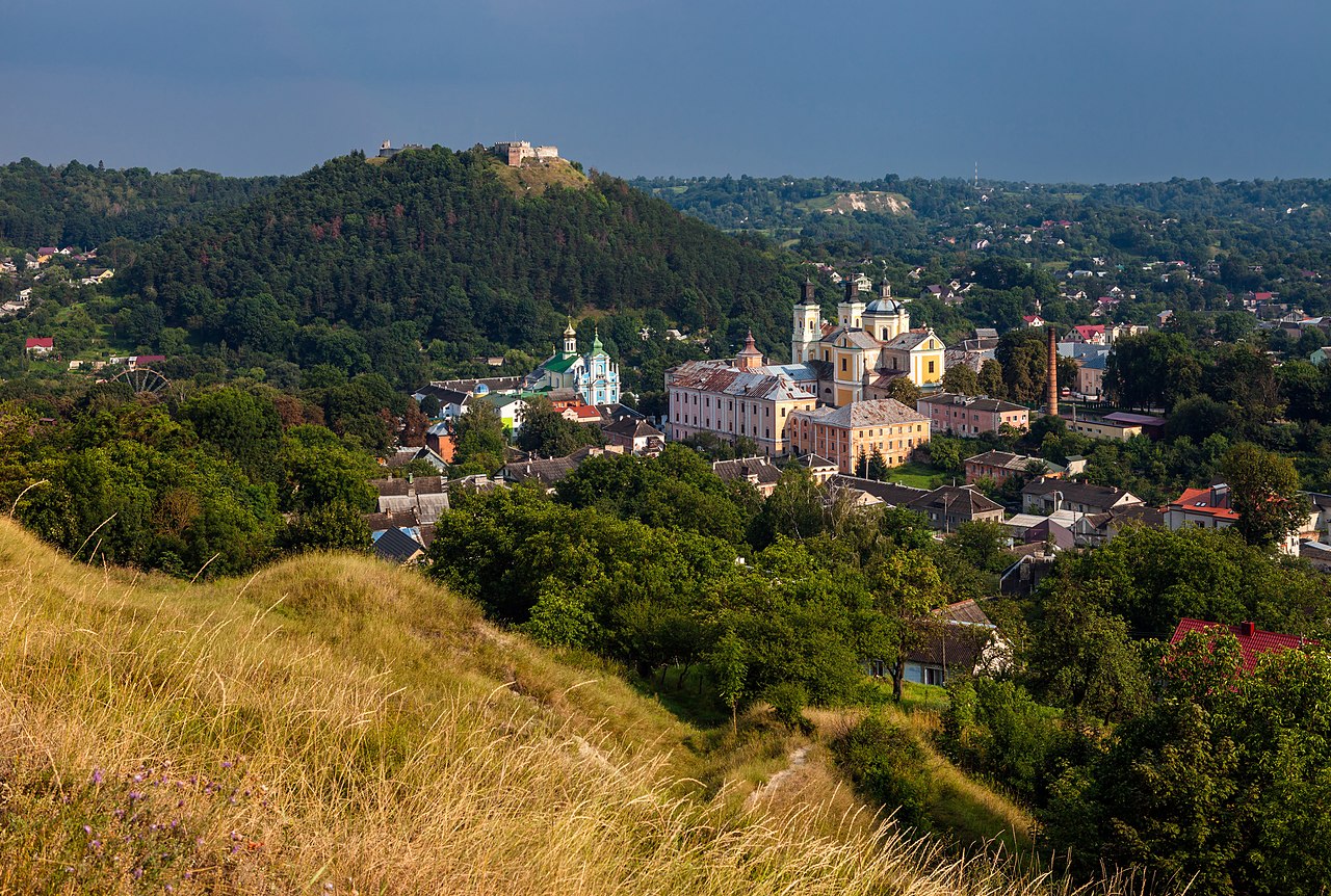 Panoramiczny widok na Krzemieniec na Ukrainie, ukazujący jego zabytkową architekturę, w tym Zamek w Krzemieńcu i Monaster Świętej Trójcy.