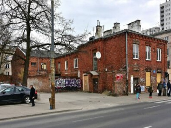 Opuszczony ceglany budynek z graffiti, widok z ulicy