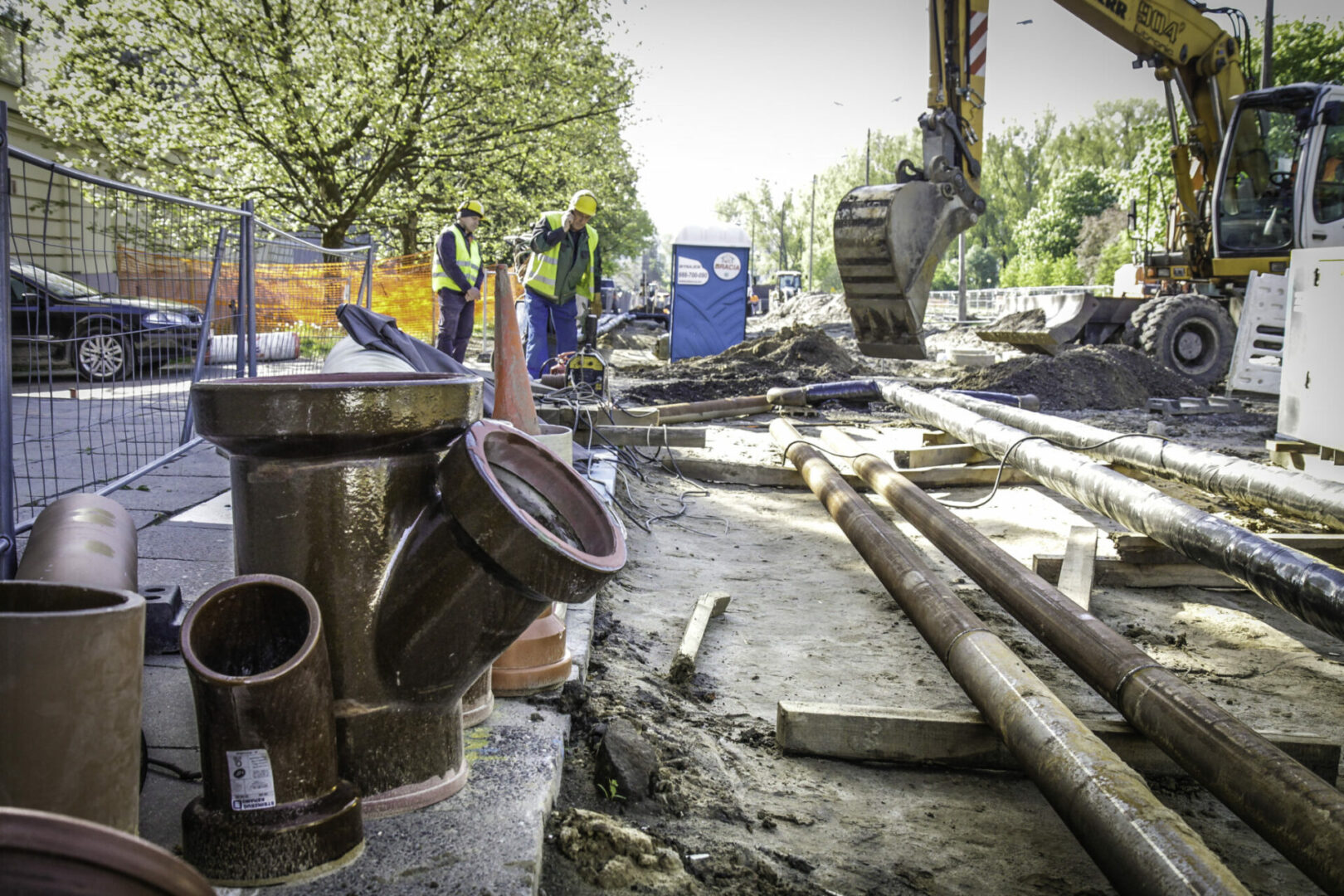Robotnicy budowlani instalują nowe rury wodociągowe pod ziemią.