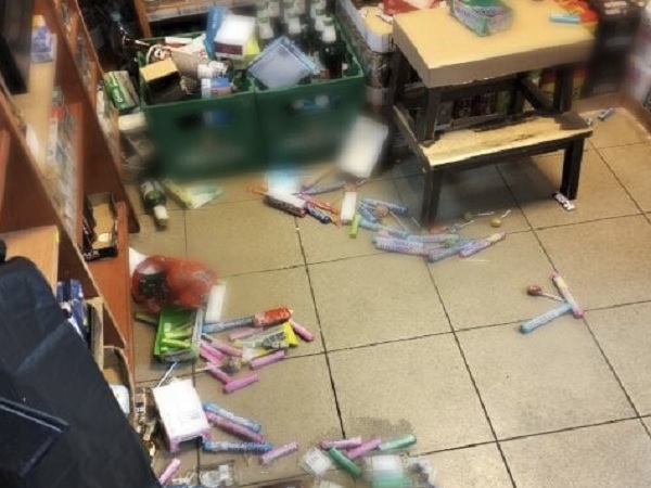 Wnętrze sklepu pełne bałaganu po napadzie, słodycze rozrzucone na podłodze.