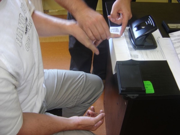 Proces nakładania tuszu na odciski palców i pobierania odcisków palców