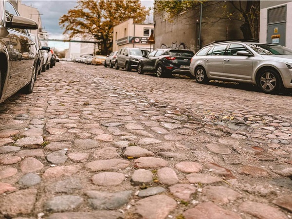 Samochody zaparkowane na brukowanej ulicy w europejskim mieście.