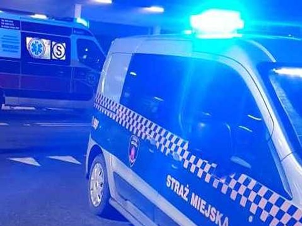 Pojazdy uprzywilejowane w nocy; widoczna karetka pogotowia i radiowóz policji miejskiej ze Strażą Miejską.