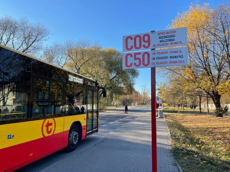 Przystanek autobusowy w Warszawie z liniami autobusowymi C09 i C50, na zdjęciu widoczny autobus w kolorze czerwonym i żółtym.
