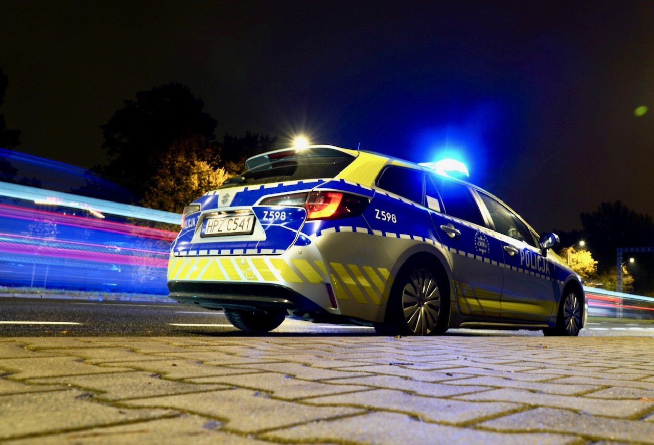 Polski radiowóz, HPZ C541, nocą z włączonymi światłami.