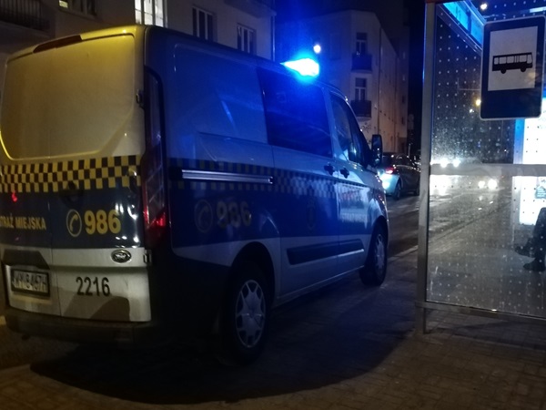 Samochód policyjny zaparkowany nocą, widoczny numer 2216, 986